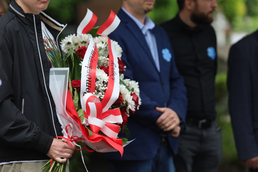 Uroczystość złożenia kwiatów pod Pomnikiem. Fotografia przedstawia wiązankę kwiatową