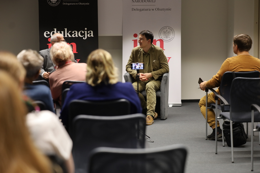 Dr Filip Gańczak i dr Waldemar Brenda podczas spotkania z publicznością w Delegaturze IPN w Olsztynie. W tle banery Instytutu Pamięci Narodowej.